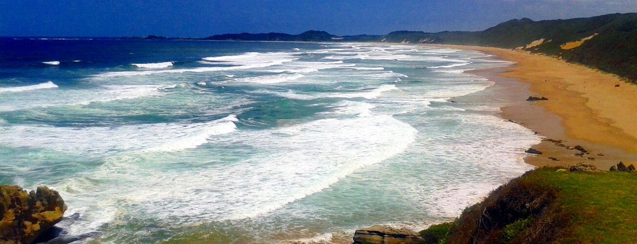 Surf rolling onto a long sandy beach